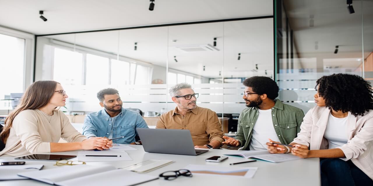 Business leaders reviewing IT strategy and performance metrics in a modern office
