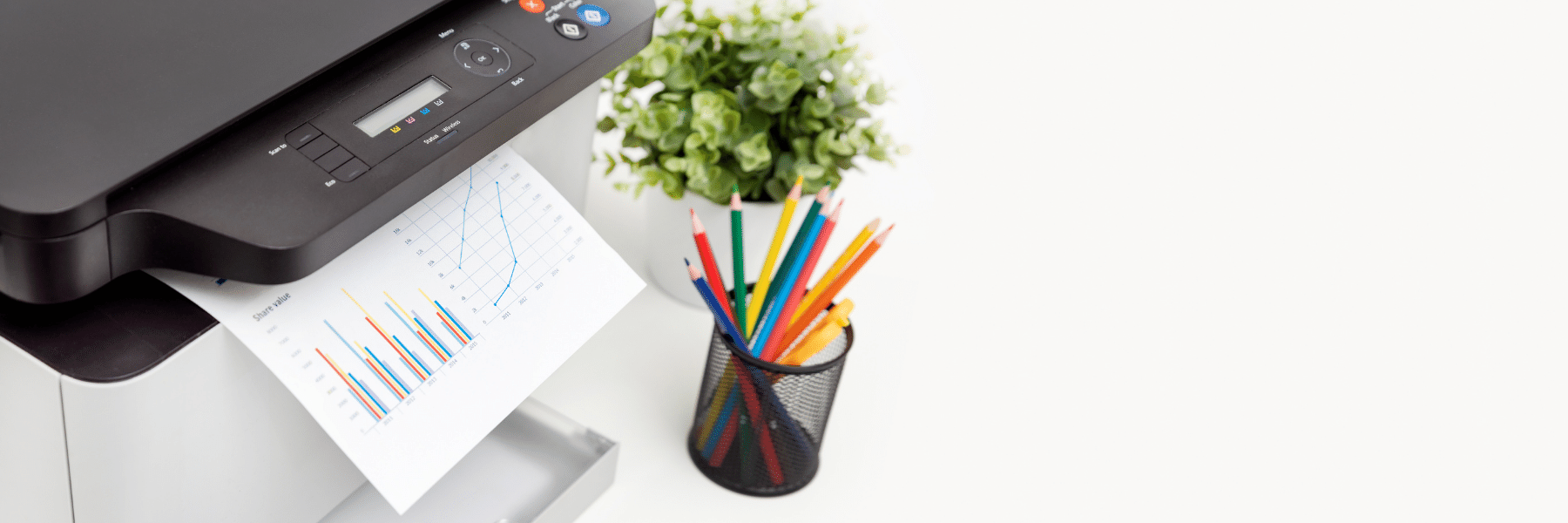 office copier on a table with a plant and container of pens