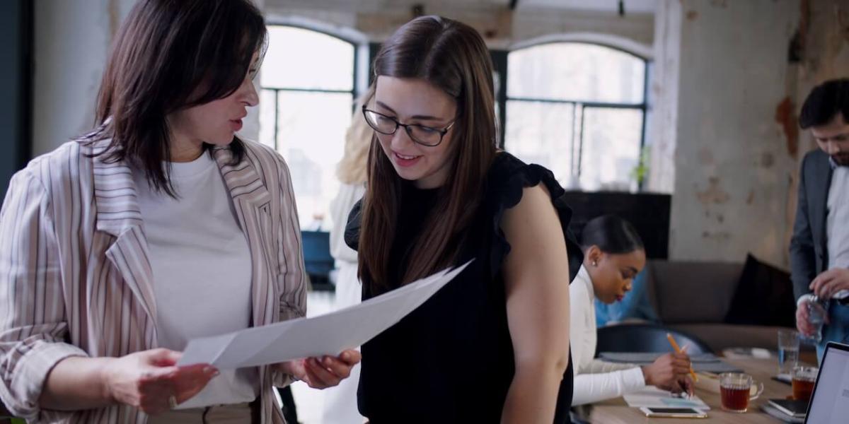 hotel manager and receptionist talking over guest receipt
