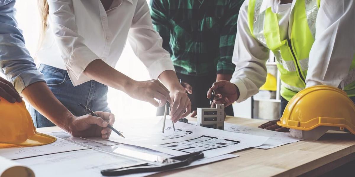Construction professionals reviewing large-format blueprints at an active job site
