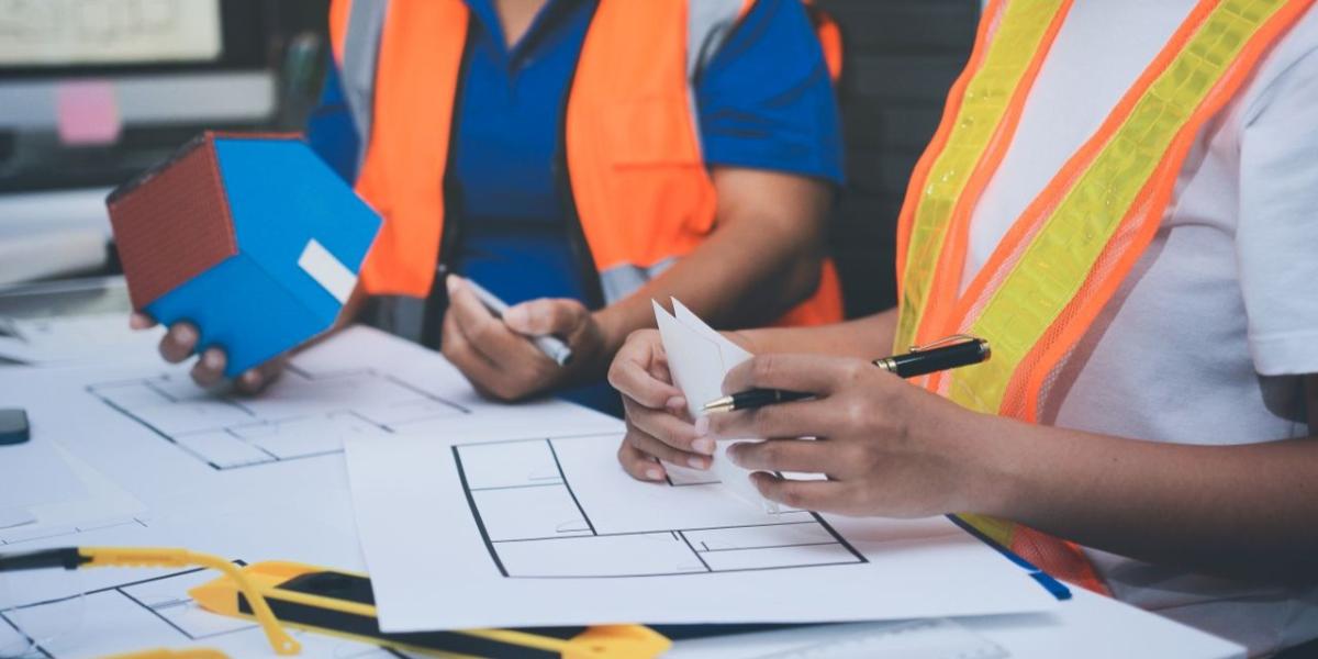 Construction professionals reviewing large-format blueprints at an active job site
