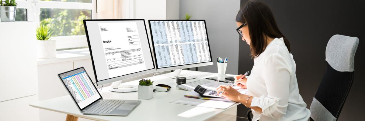 Accountant working on tax documents on multiple screens