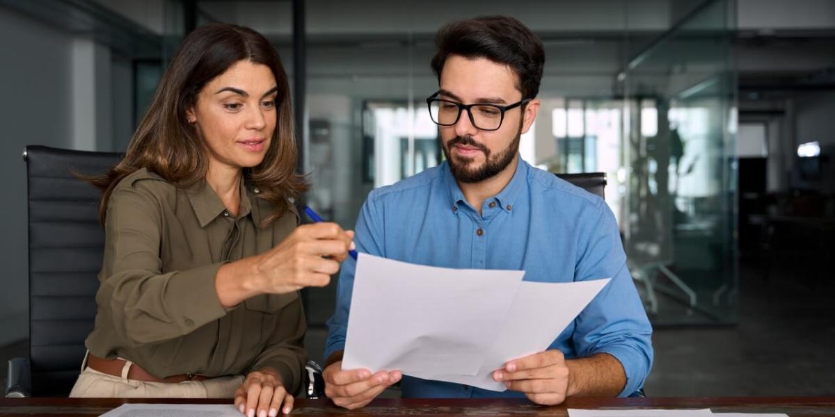 hotel manager and receptionist talking over guest receipt