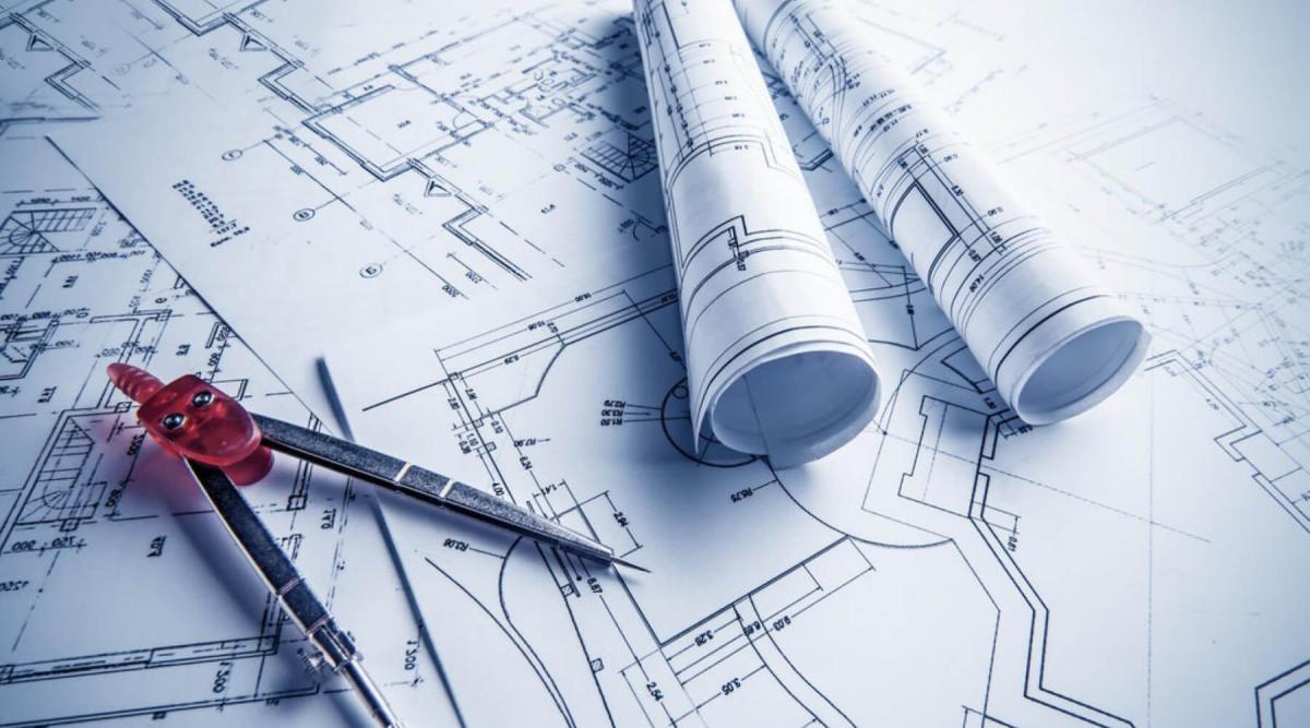 Building plans laid across a table, symbolizing Architecture & Engineering